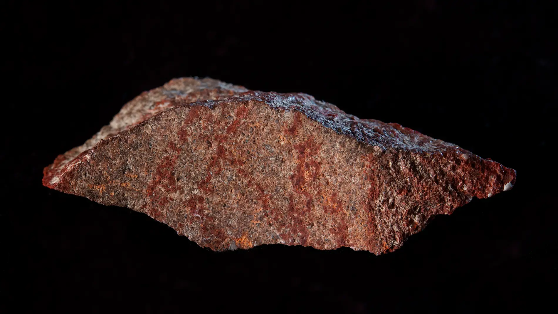 Lámina de roca con líneas pintadas color rojo