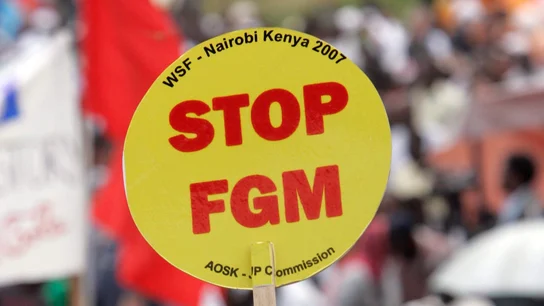 Una mujer levanta una pancarta en la que dice "Poned fin a la mutilación genital femenina (FGM)' durante una gran manifestación, desde Kibera, el mayor barrio marginal de Africa en Nairobi, Kenia Una mujer levanta una pancarta en la que dice "Poned fin a la mutilación genital femenina (FGM)' durante una gran manifestación, desde Kibera, el mayor barrio marginal de África en Nairobi, Kenia