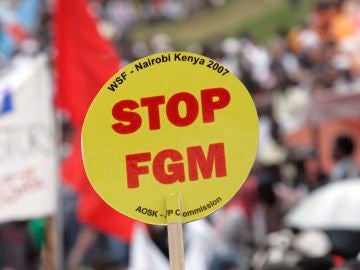 Una mujer levanta una pancarta en la que dice "Poned fin a la mutilación genital femenina (FGM)' durante una gran manifestación, desde Kibera, el mayor barrio marginal de Africa en Nairobi, Kenia Una mujer levanta una pancarta en la que dice "Poned fin a la mutilación genital femenina (FGM)' durante una gran manifestación, desde Kibera, el mayor barrio marginal de Africa en Nairobi, Kenia