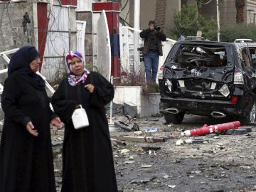 Un grupo de personas permanece en el lugar donde explotó un coche bomba, en Bagdad, Irak Un grupo de personas permanece en el lugar donde explotó un coche bomba, en Bagdad, Irak