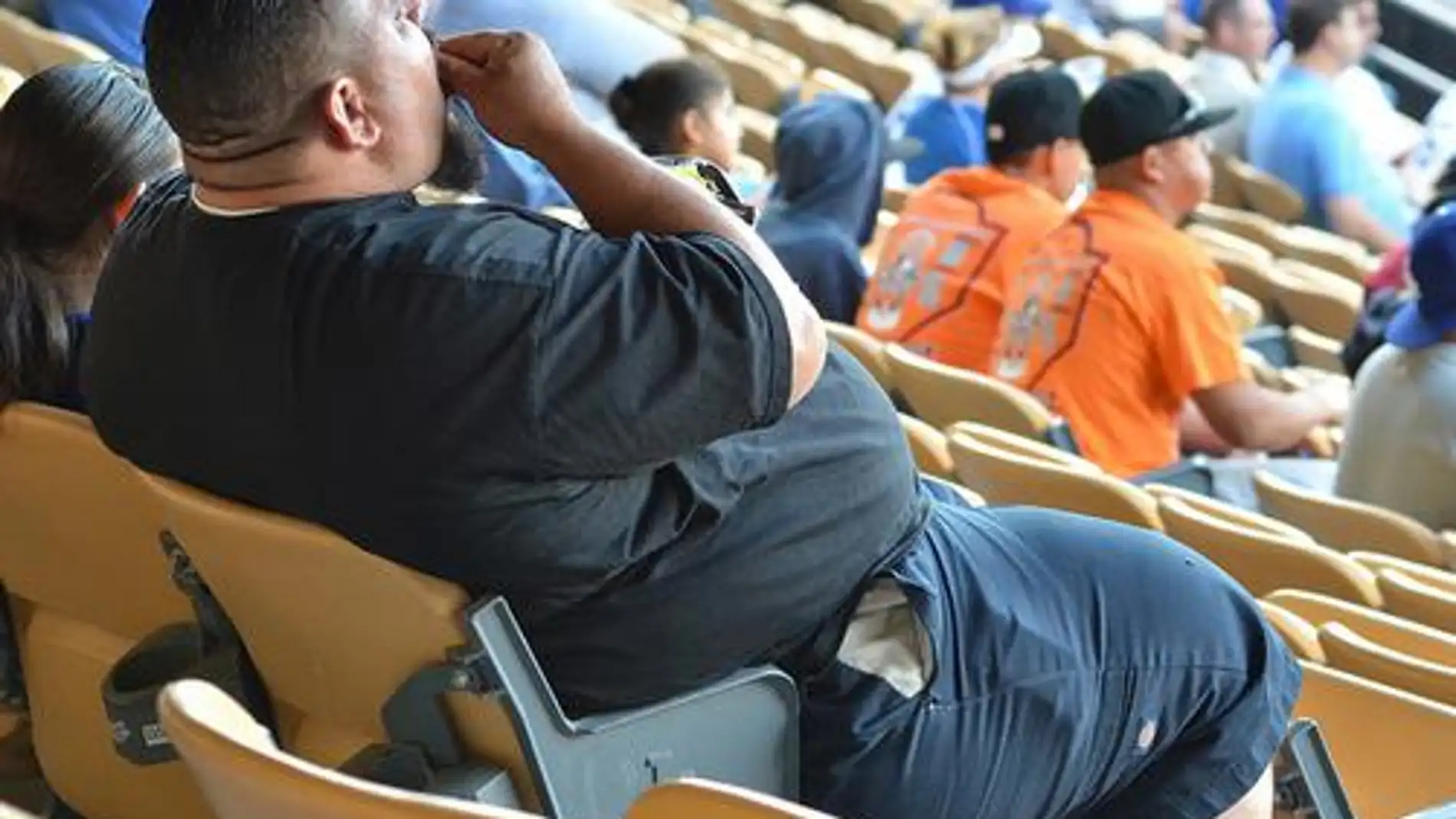 hombre obeso comiendo palomitas