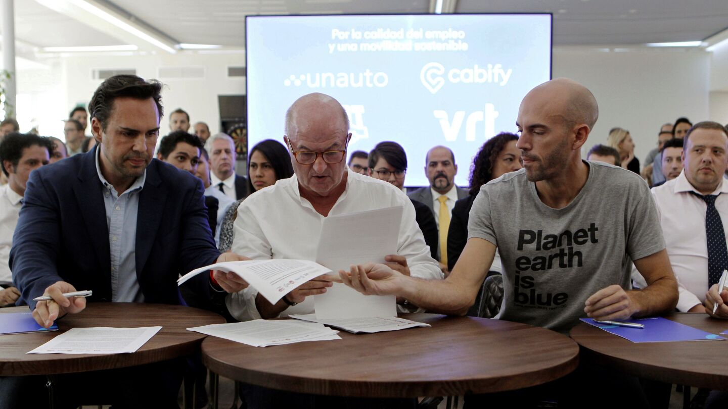 El presidente de Unauto VTC, Eduardo Mart&iacute;n; el secretario general de FeSMC-UGT, Miguel &Aacute;ngel Cilleros; y el consejero delegado de Cabify, Juan de Antonio.
