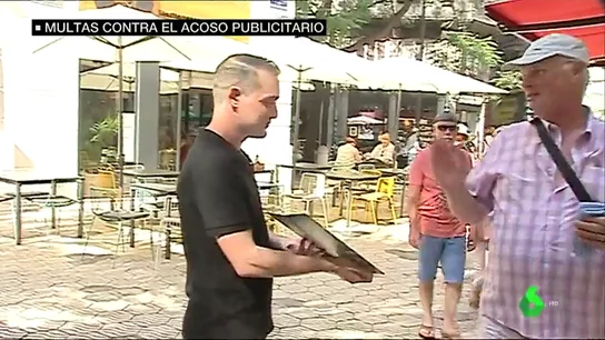 Un camarero aborda a un viandante en la calle Un camarero aborda a un viandante en la calle