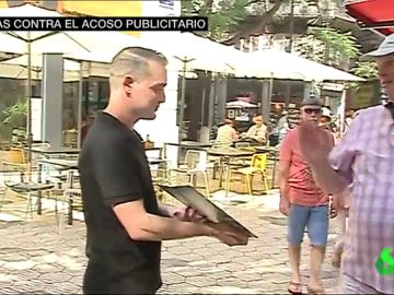 Un camarero aborda a un viandante en la calle Un camarero aborda a un viandante en la calle