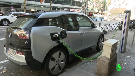 Un coche eléctrico recargándose Un coche eléctrico recargándose