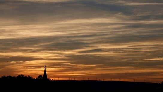 El &uacute;ltimo sol del verano se pone sobre los aerogeneradores de la sierra de Badaia