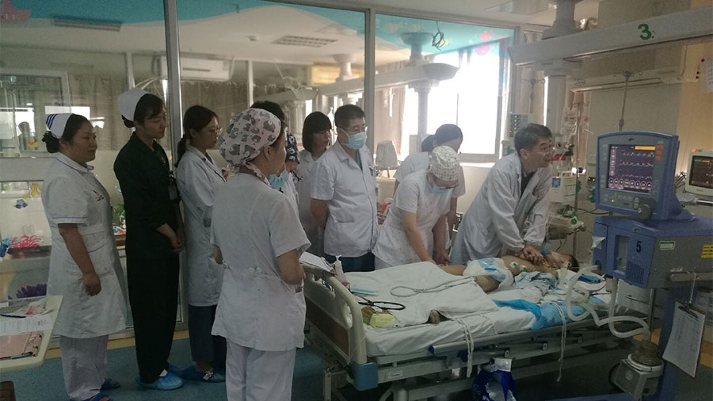 Imagen de los m&eacute;dicos chinos junto a la cama del ni&ntilde;o