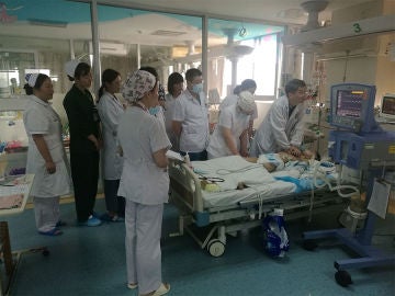 Imagen de los médicos chinos junto a la cama del niño Imagen de los médicos chinos junto a la cama del niño