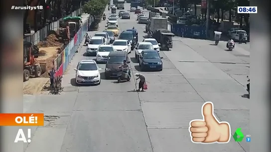 Un motorista para el tráfico para que una señora pueda cruzar la calle Un motorista para el tráfico para que una señora pueda cruzar la calle