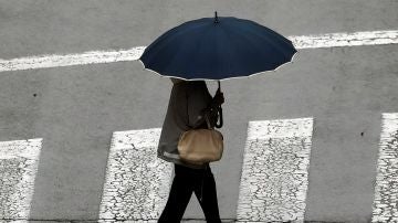 Una mujer se protege con un paraguas ante la lluvia