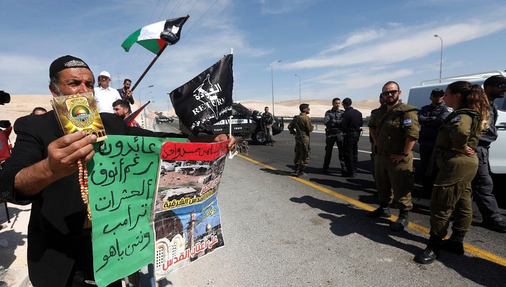 Manifestantes ondean banderas palestinas mientras protestan ante tropas de Israel