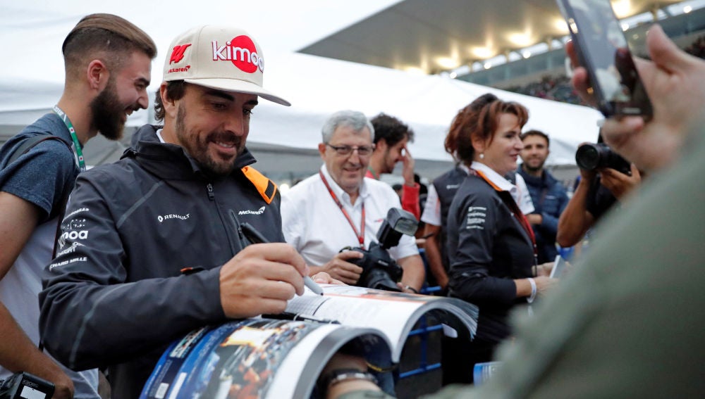 Fernando Alonso firma a un aficionado en el trazado de Suzuka