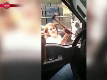 Una señora destroza un retrovisor con un martillo Una señora destroza un retrovisor con un martillo