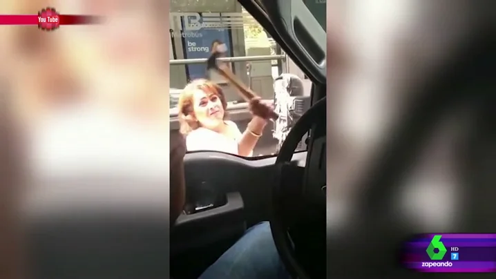 Una señora destroza un retrovisor con un martillo