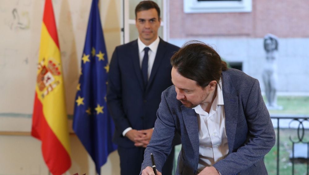 El secretario general de Podemos, Pablo Iglesias, firmando el acuerdo presupuestario