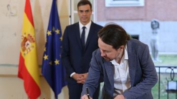 El secretario general de Podemos, Pablo Iglesias, firmando el acuerdo presupuestario