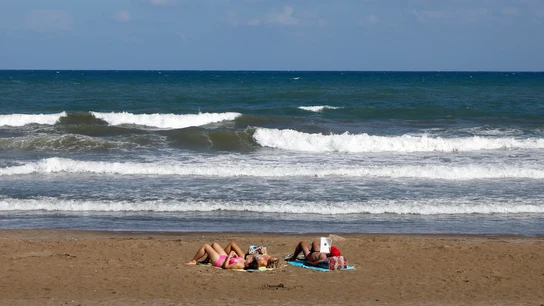 Tres personas toman el sol, el pasado mes de septiembre en la playa de la Malvarrosa de Valencia Tres personas toman el sol, el pasado mes de septiembre en la playa de la Malvarrosa de Valencia