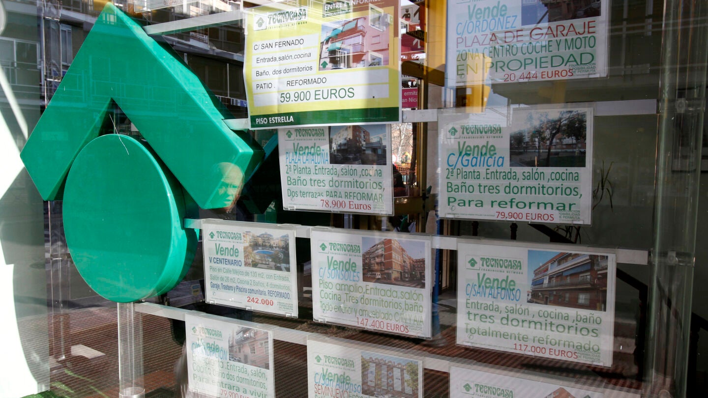Numerosos carteles de venta de pisos ocupan el escaparate de una entidad inmobiliaria