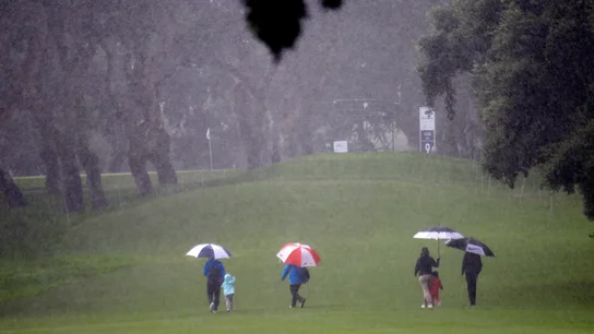 Espectadores cruzan bajo la fuerte lluvia uno de los hoyos del campo del Real Club Espectadores cruzan bajo la fuerte lluvia uno de los hoyos del campo del Real Club