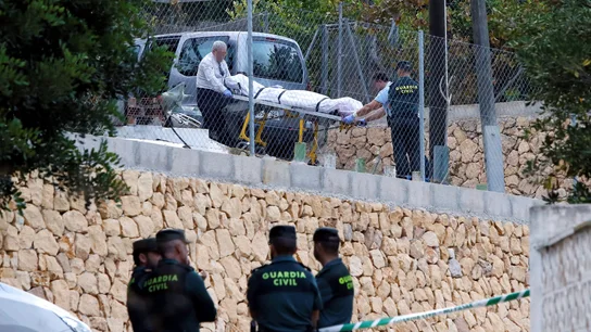 Miembros de los servicios funerarios trasladan uno de los cuerpos Miembros de los servicios funerarios trasladan uno de los cuerpos