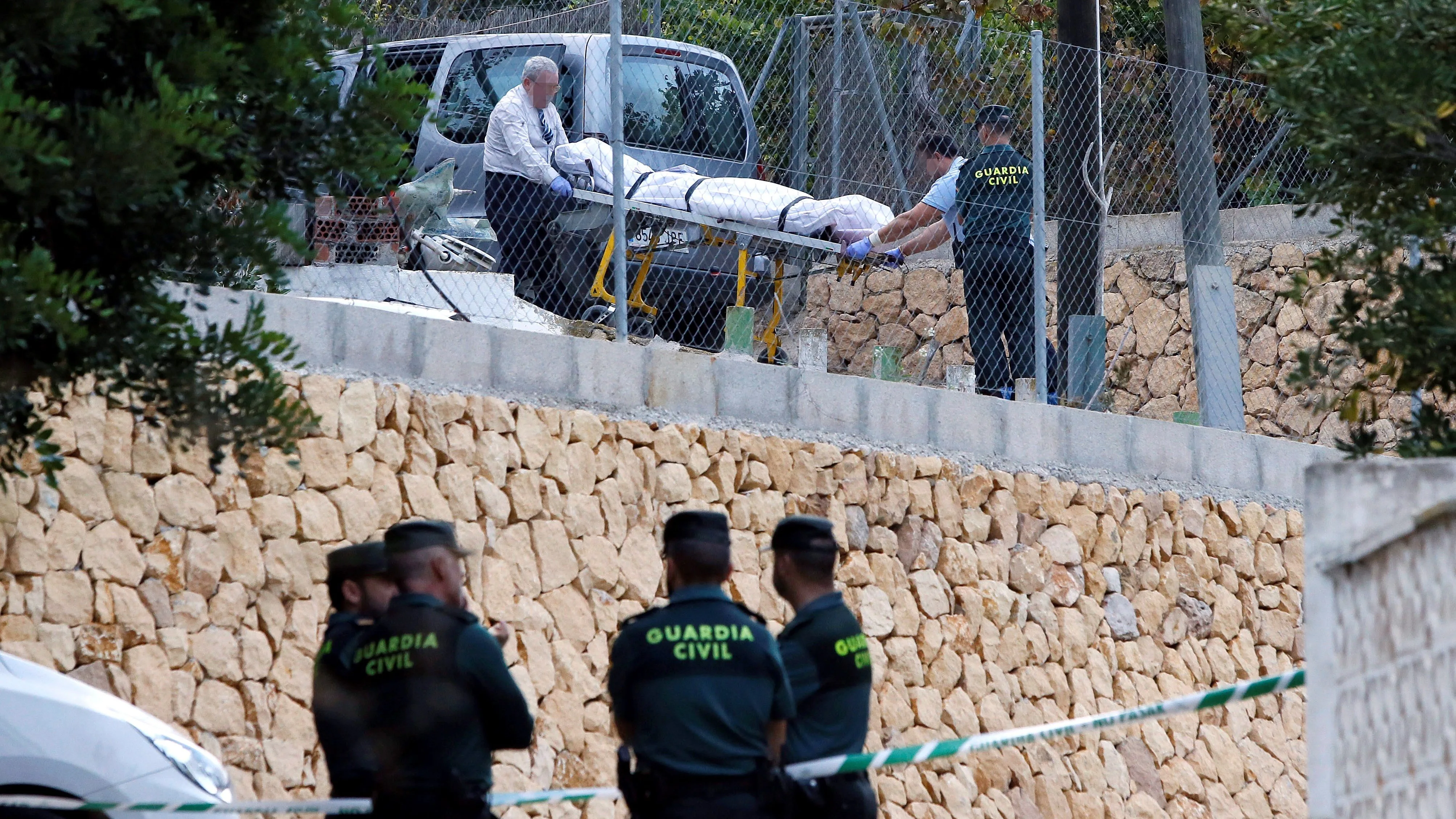 Miembros de los servicios funerarios trasladan uno de los cuerpos