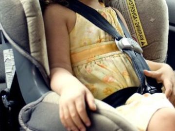 Imagen de archivo de una niña en una sillita en un coche Imagen de archivo de una niña en una sillita en un coche