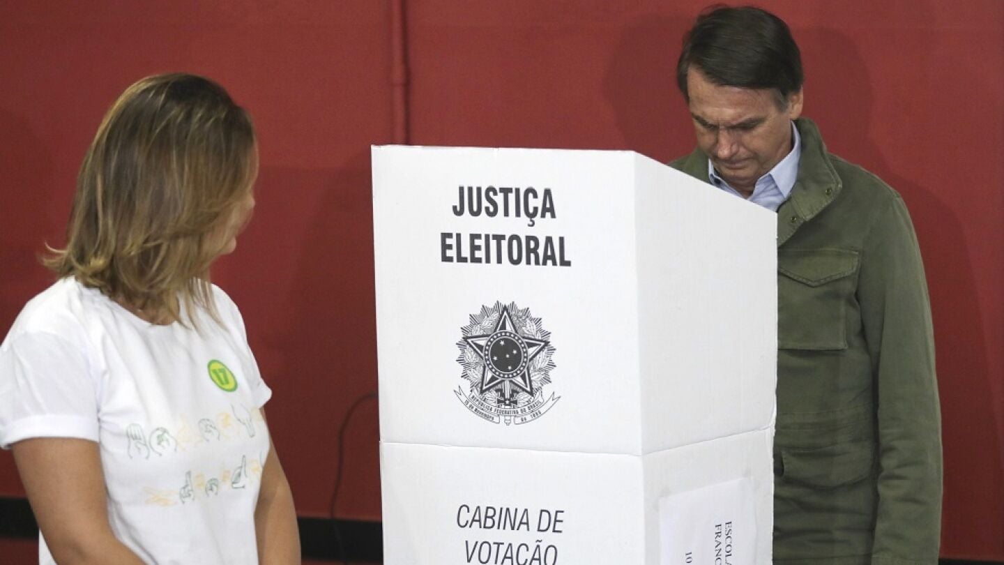 El candidato ultraderechista Jair Bolsonaro, acompa&ntilde;ado de su esposa, Michelle, vota en una &aacute;rea militar en la zona norte de R&iacute;o de Janeiro