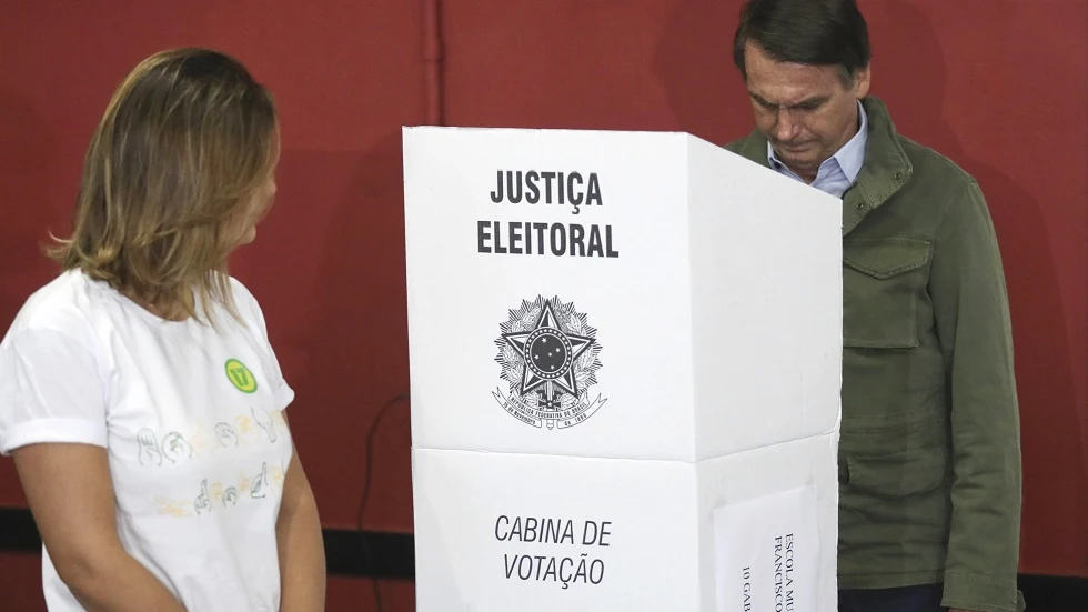 El candidato ultraderechista Jair Bolsonaro, acompañado de su esposa, Michelle, vota en una área militar en la zona norte de Río de Janeiro