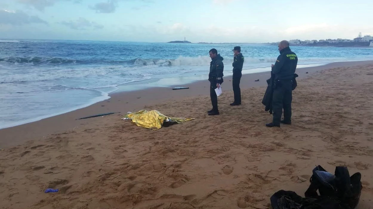 Fotografía facilitada por la Guardia Civil que muestra a agentes junto al cuerpo de uno de los inmigrantes fallecidos en la costa de Melilla