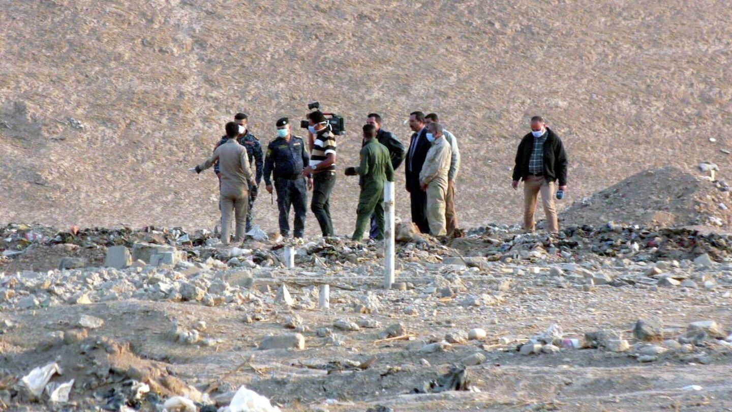 Personal forense iraqu&iacute; inspecciona una zona en la que fue descubierta una fosa com&uacute;n al sur de Mosul