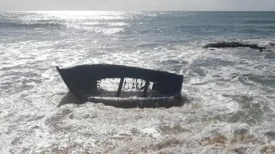 Imagen de archivo de una patera naufragada Estado en el que quedó una patera tras chocar contra una roca en la playa de Caños de Meca
