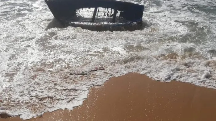 Estado en el que quedó una patera tras chocar contra una roca en la playa de Caños de Meca