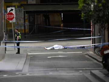 El cadáver de una víctima yace sobre el asfalto El cadáver de una víctima yace sobre el asfalto