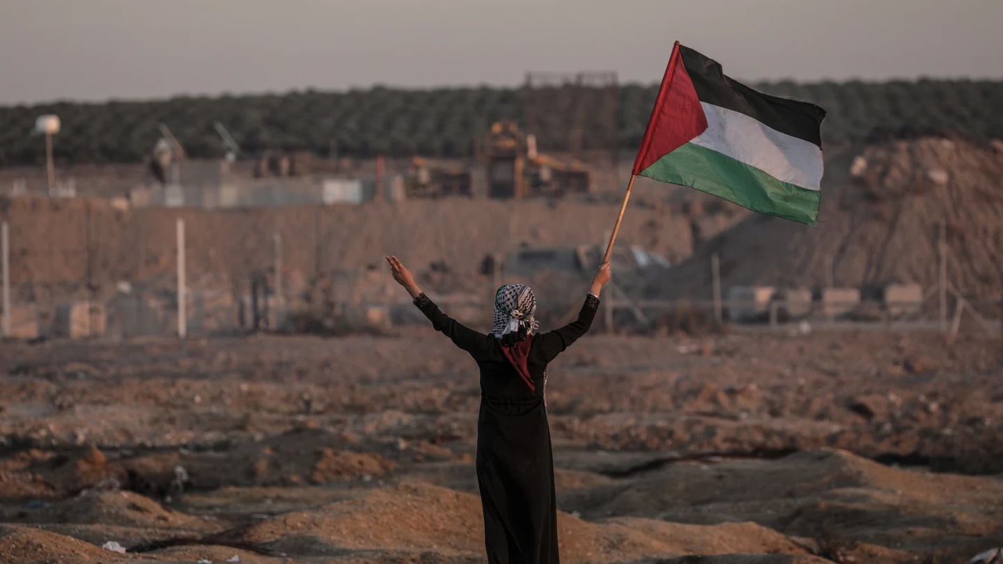 Una mujer ondea una bandera de Palestina Una mujer ondea una bandera de Palestina