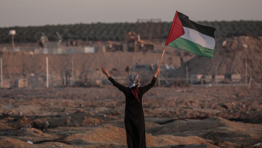Una mujer ondea una bandera de Palestina