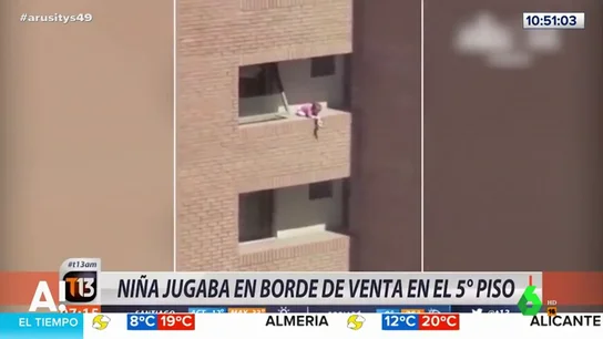 Una niña jugando al borde del balcón de un quinto piso Una niña jugando al borde del balcón de un quinto piso