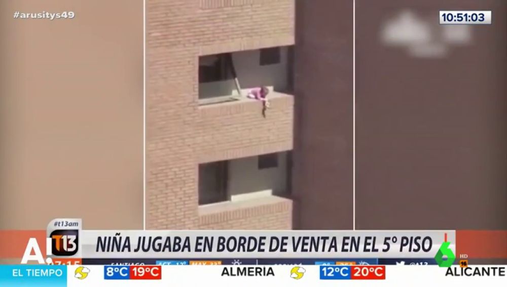 Una niña jugando al borde del balcón de un quinto piso