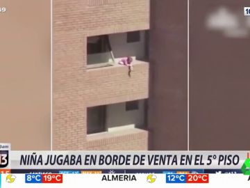 Una niña jugando al borde del balcón de un quinto piso Una niña jugando al borde del balcón de un quinto piso