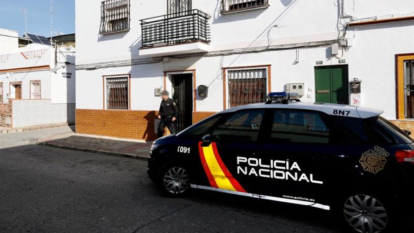 Un agente de la Polic&iacute;a Nacional sale de la vivienda de Alcal&aacute; de Guadaira
