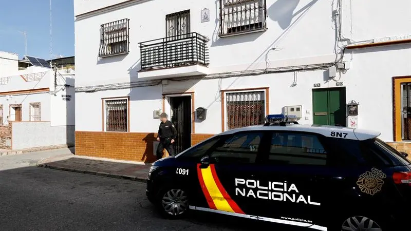 Un agente de la Policía Nacional sale de la vivienda de Alcalá de Guadaira