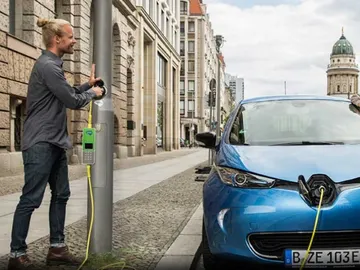 Coche eléctrico repostando en una farola pública Coche eléctrico repostando en una farola pública