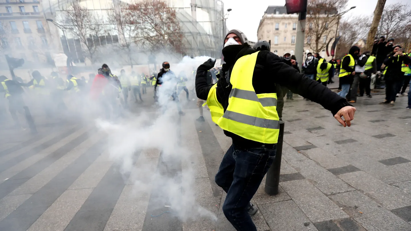 Un manifestante de los 'chalecos amarillos' lanza gas lacrimogeno Un manifestante de los 'chalecos amarillos' lanza gas lacrimogeno