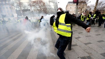 Un manifestante de los 'chalecos amarillos' lanza gas lacrimogeno