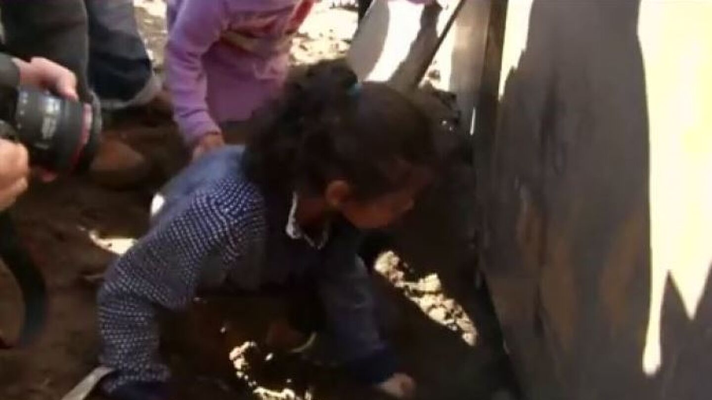 Menor cruzando la valla fronteriza de EEUU