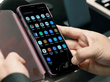 Una persona revisa la pantalla de un móvil Una persona revisa la pantalla de un móvil