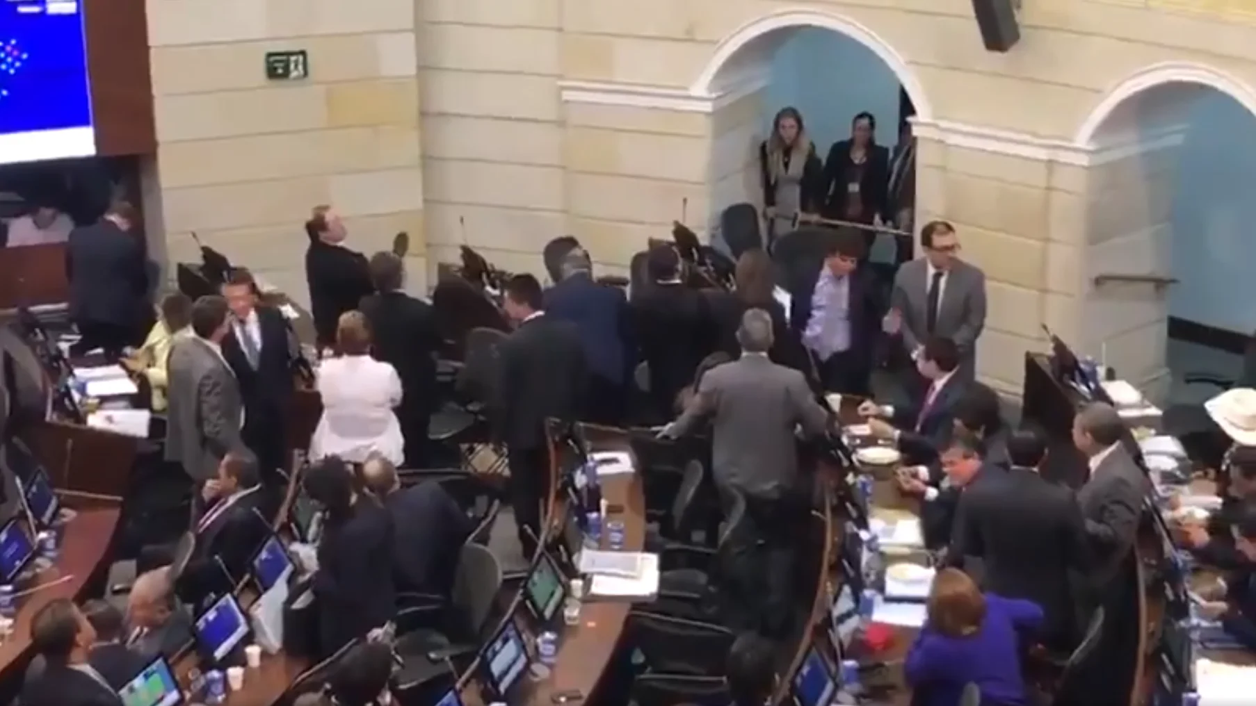 Diputados de Centro Democrático se levantan de sus asientos en el pleno del Congreso colombiano.