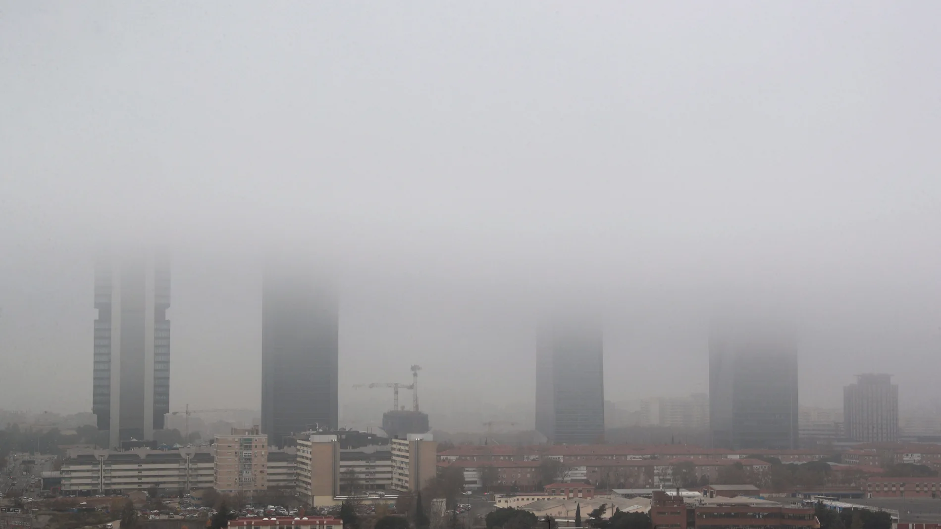 Vista de las Cuatro Torres de Madrid cubiertas por la niebla