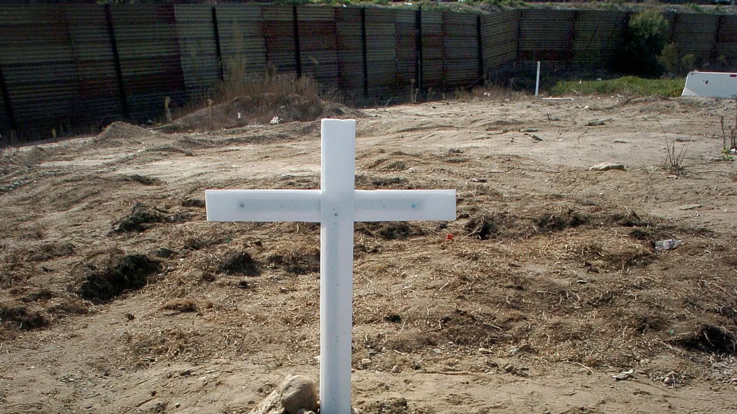 Una cruz al frente del muro que separa la frontera entre Estados Unidos y México Una cruz al frente del muro que separa la frontera entre Estados Unidos y México