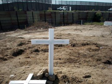 Una cruz al frente del muro que separa la frontera entre Estados Unidos y México Una cruz al frente del muro que separa la frontera entre Estados Unidos y México