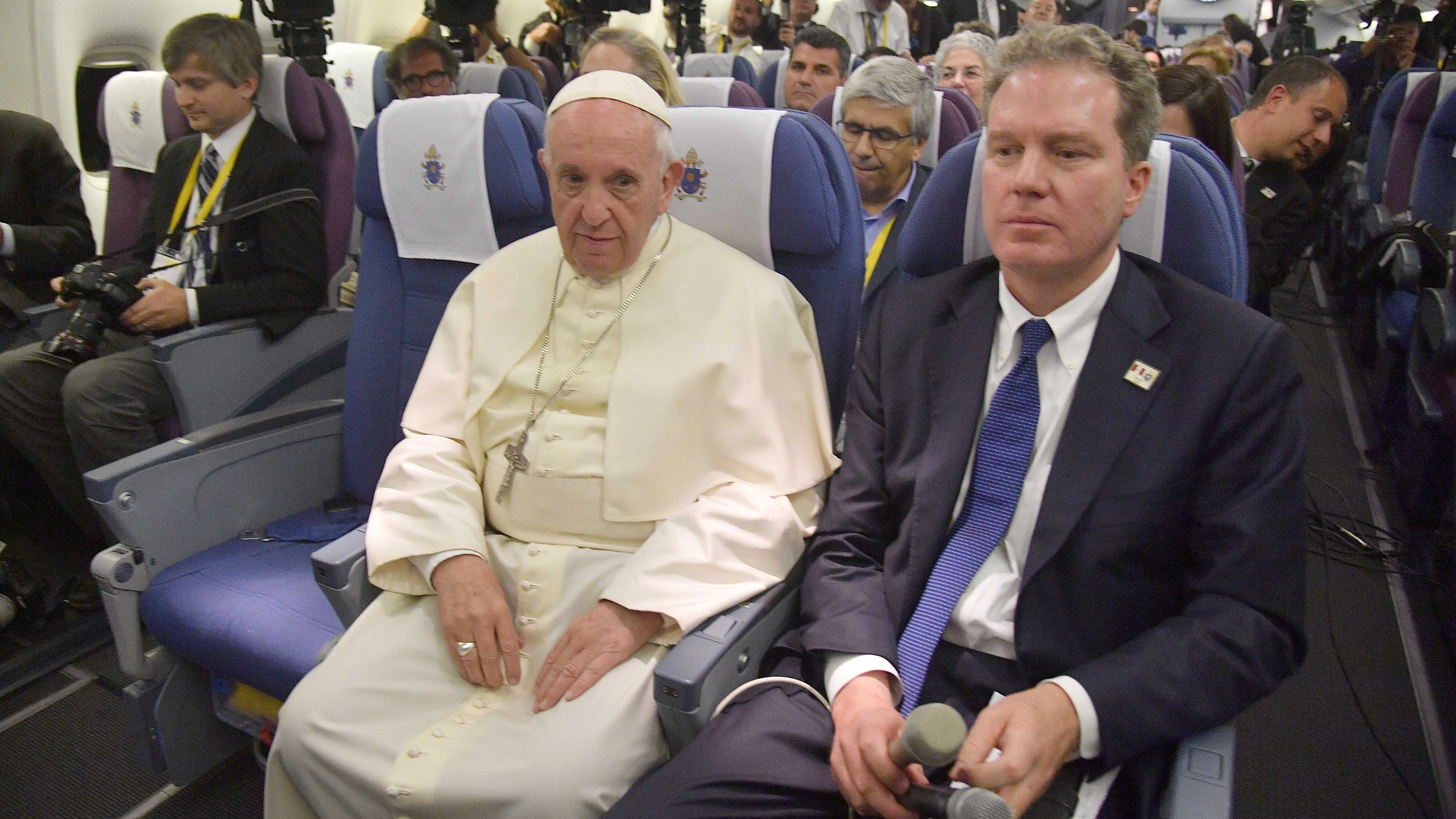 El papa Francisco y el director de la Oficina de Prensa de la Santa Sede, Greg Bruke, a bordo del avión durante un vuelo de regreso a Italia tras una visita apostólica.